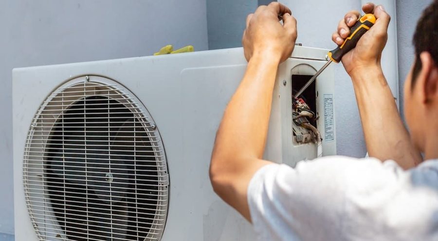 HVAC technician performing maintenance on a heat pump