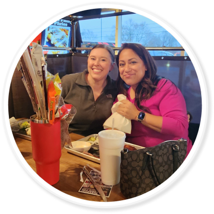 two people sit at a table smiling at the camera